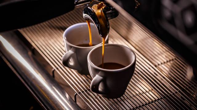 Frischer Espresso läuft in zwei weiße Tassen