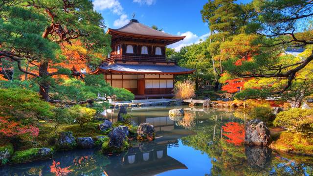Japanischer Tempel am Teich, bunte Bäume im Herbst