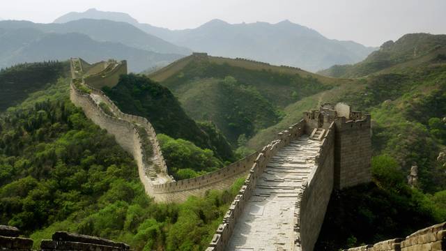 Große Mauer in China, schlängelt sich über grüne Hügel