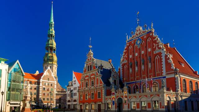 Historischer Rathausplatz in Riga, Lettland, mit dem prachtvollen Haus der Schwarzhäupter und dem markanten Kirchturm der Petrikirche
