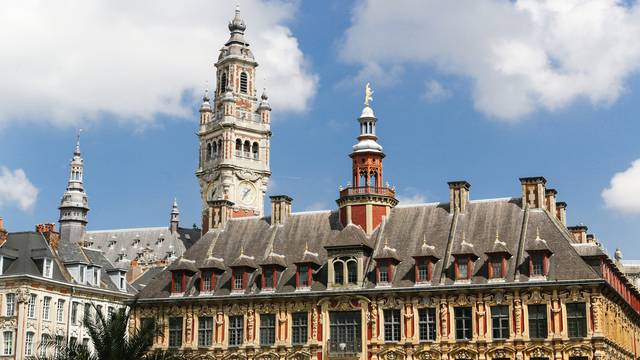Historisches Gebäude mit Uhrenturm in Lille, Frankreich, unter blauem Himmel