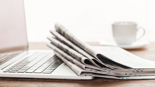 Gestapelte Zeitungen liegen auf einer Laptoptastatur