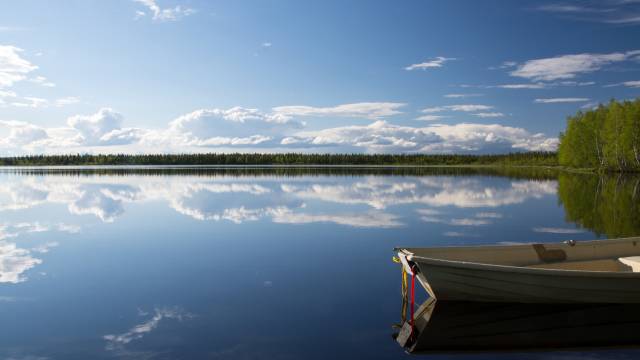 Ein stiller See in Lappland, der den Himmel und die Wälder wie ein Spiegel reflektiert