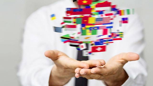 Viele bunte Länderflaggen schweben über geöffneten Händen