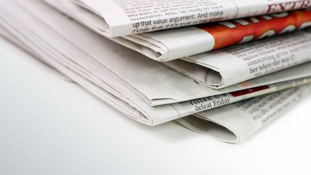 Gestapelter Zeitungsstapel in Nahaufnahme auf weißem Hintergrund